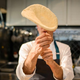 Pizzaiolo tossing pizza dough in restaurant